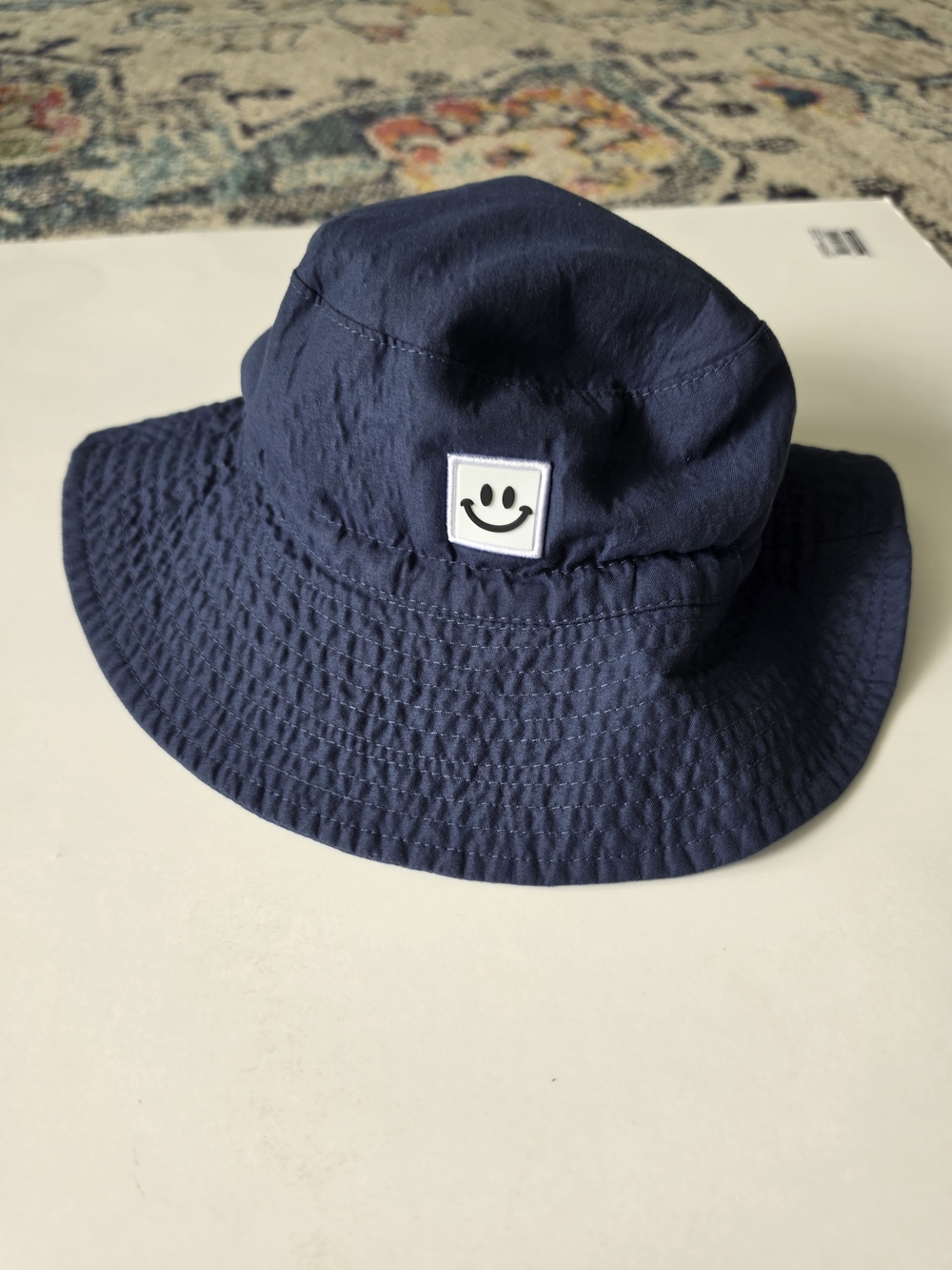 Navy blue smiley face bucket hat with UPF 50+ sun protection  Toddler